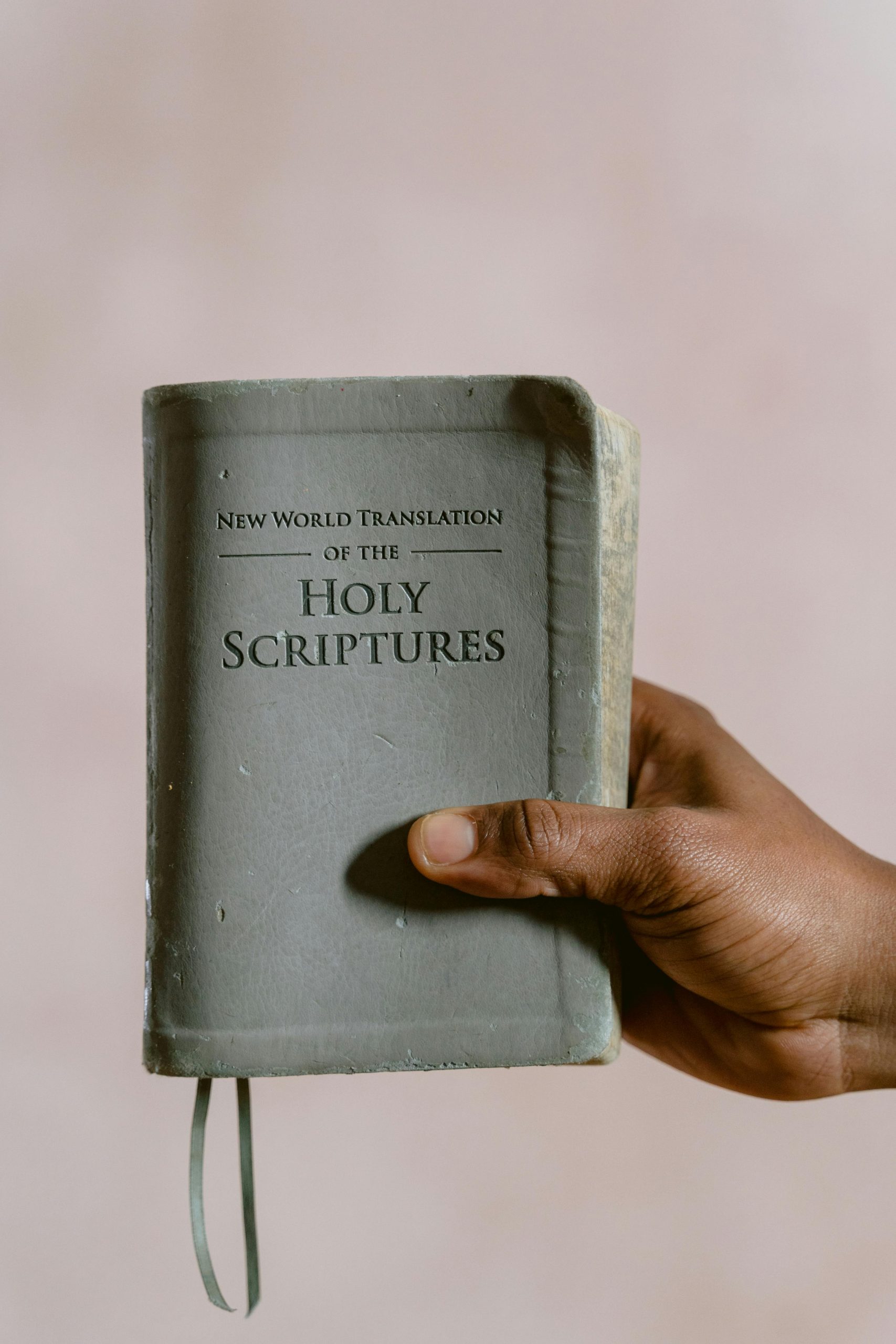 Close-up of a hand holding the Holy Scriptures, focusing on religious and spiritual themes.